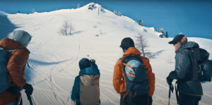 a family of four looks up at a snow-covered mountain