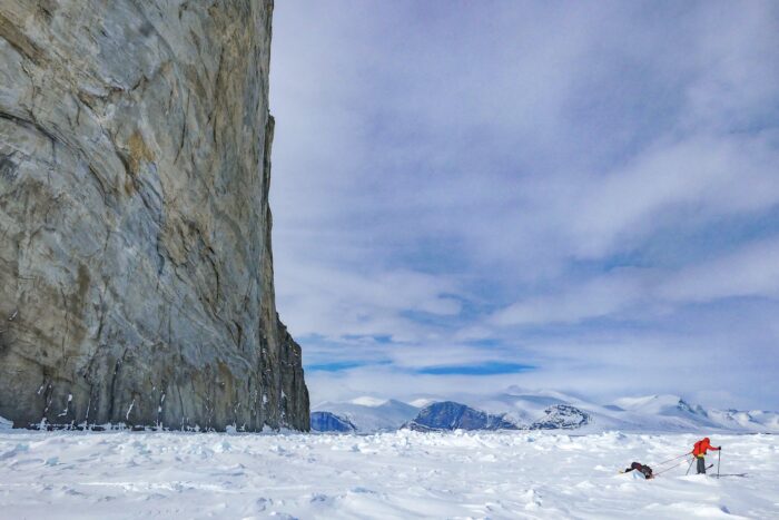 lone traveler in red on sea ice