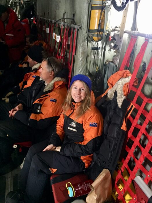 jacketed woman sitting among jacketed people