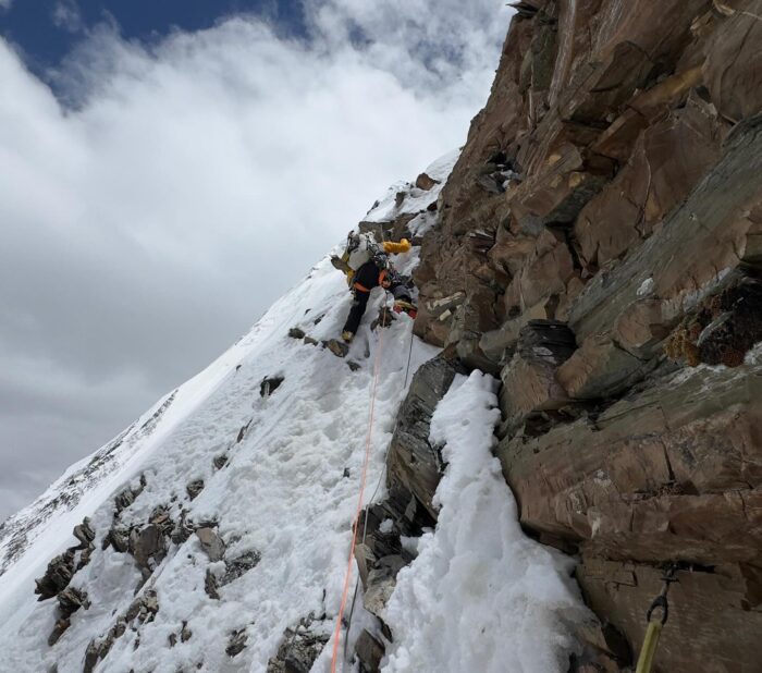 a climber on an overhanging mixed section.