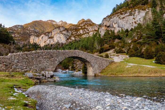 an arched bridge in pristine wilderness