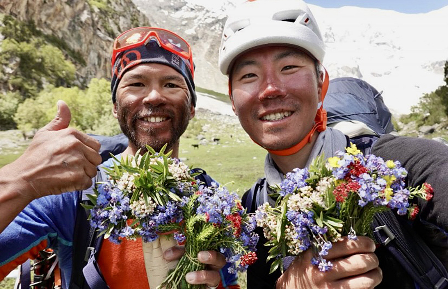 Hiraide and Nakajima celebrate a past climb with wreaths of flowers.