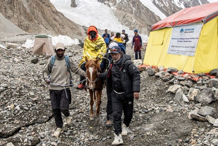 Baig on horseback led by two porters, wrapped in a thermic blanket and with supplementary O2 on. 