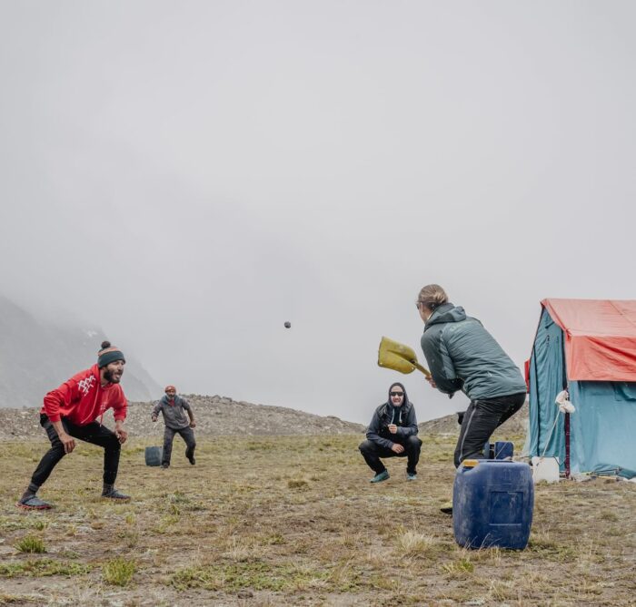 Mountaineers play baseball in the grasslands on a misty day in Pumari Chish, Pakistan