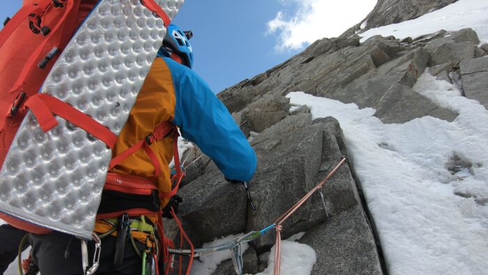 a climber with bivouac gear on mixed terrain