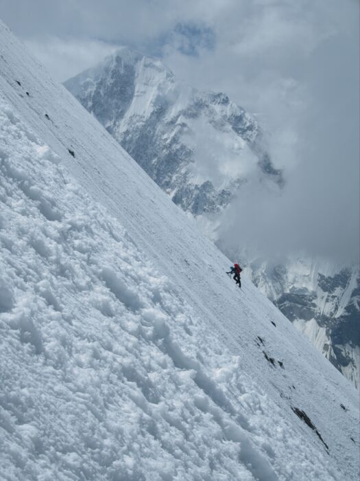 Climber on a steep snow traverse