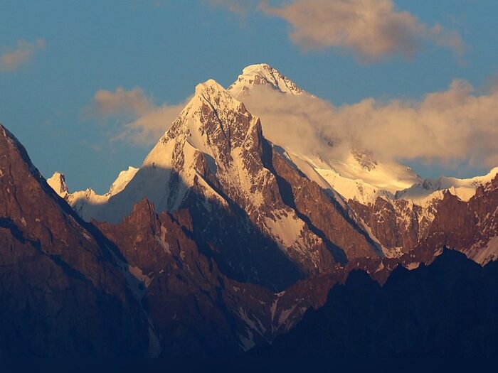 The cloud-flanked peak of Tribol at dusk, seen from Hunza, Pakistan