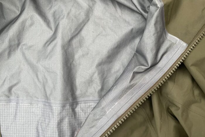 A green Arcteryx Beta AR is shown, with the outer and inner layers on display.