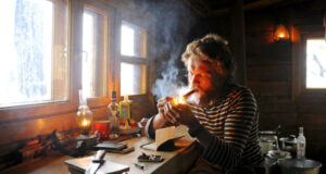 man alone in cabin smoking