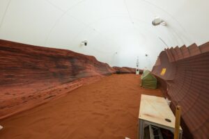 Makeshift canyons surround red sand. Overhead, a tent covers where the sky would be.