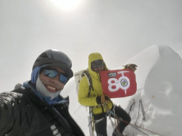 The climbers in a foggy day ona a snowy summit