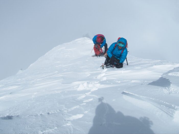 Climbers on the snowy summit ridge of Muchu Chhish