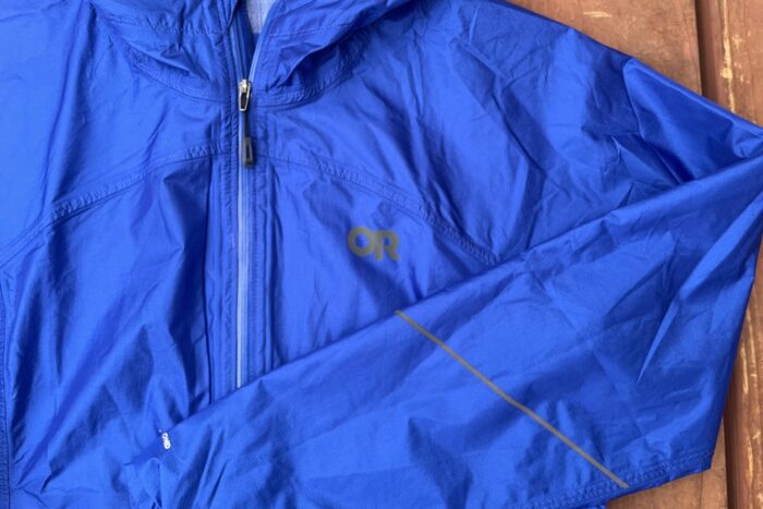 The OR Helium jacket is shown. It's blue, and has a reflective strip on the forearm and the a reflective logo. 