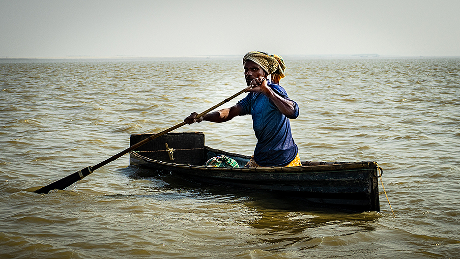 poor man in homemade boat on Ganges