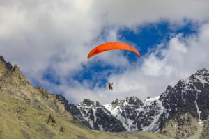 a paraglider with mountains in background