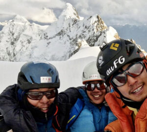 Selfie of the three climbers on a snowy summit
