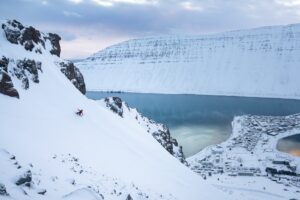 skier skiing a hillside beside the open sea