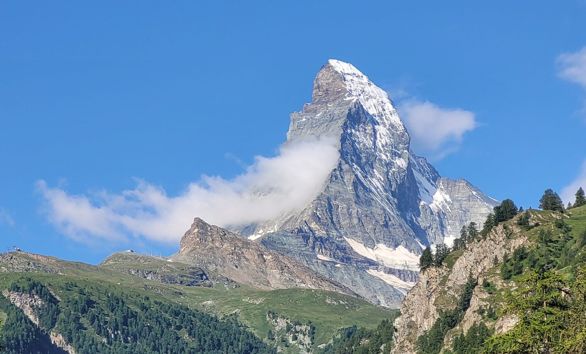 Matterhorn in a sunny day, with a cloud in the middle of its east side.