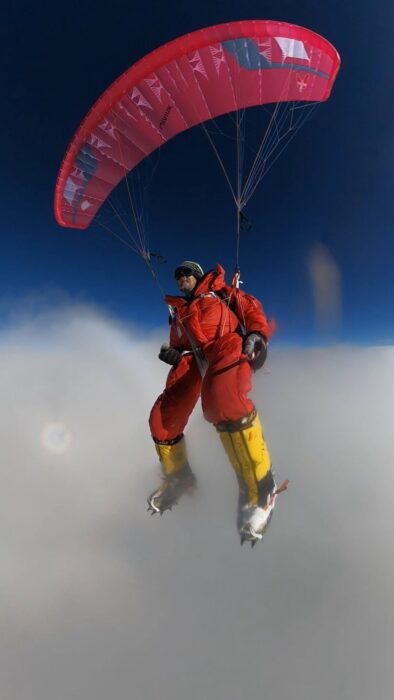 the glider with his feet sinking in the clouds below him