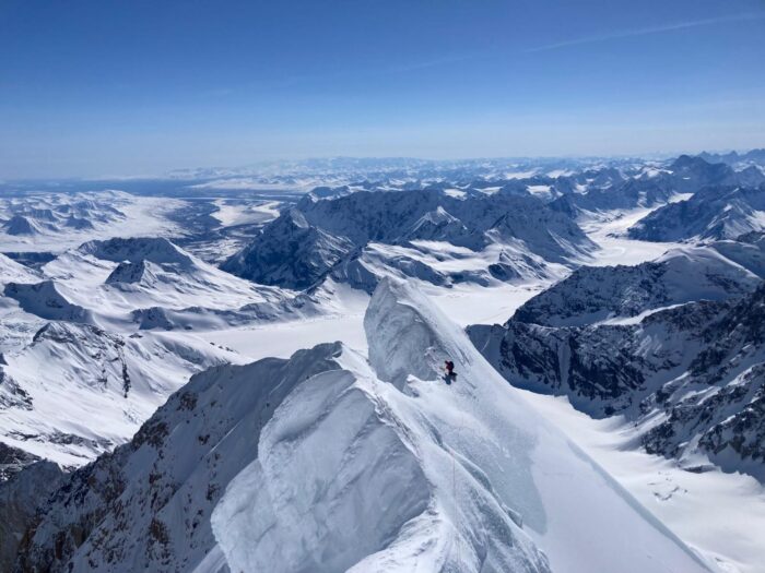 A climber on a corniced snow ridge of Mt Russell, Alaska