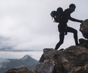 Kilian Jornet shillouetting while scrambling on a ridge in low light