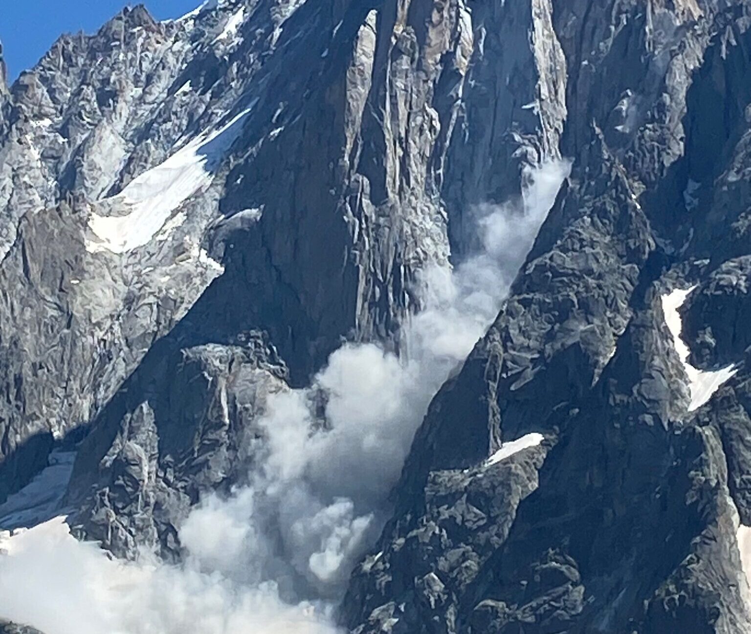 Dust created by a rockfall on the rock face of Dru, Alps