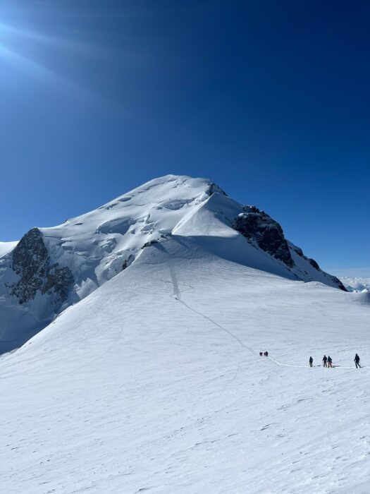 Climbers on a huge snowfield leading to the summit section