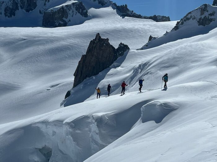 climbers on snow fields and jagged peaks