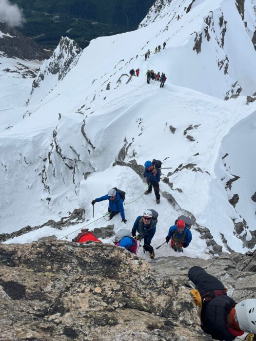 climbers as seen from above, dealing with a vertical rocky outcrop