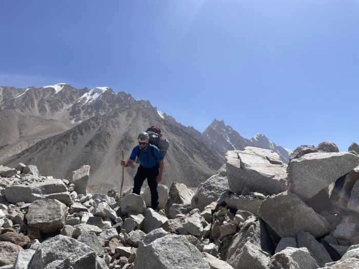 A Climber on morrain terrain with a big backpack