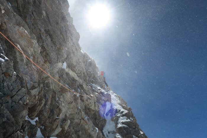 A climber on a rock and ice section of Gasherbrum III