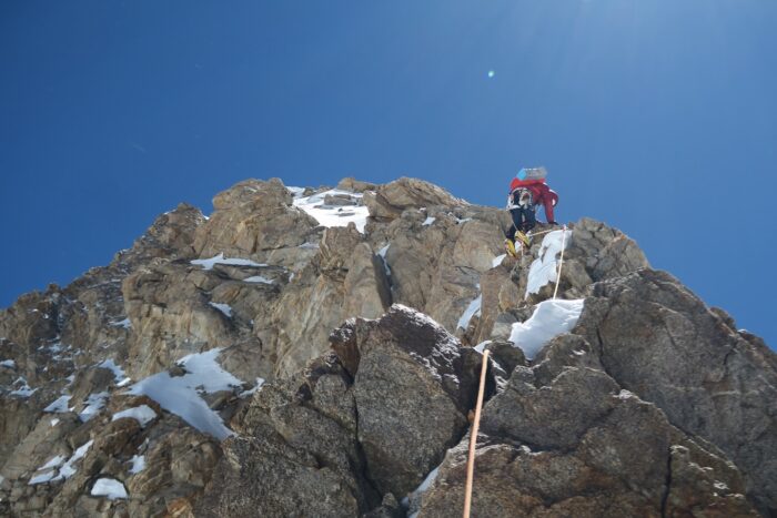 A climber on a rock and ice ridge on Gasherbrum III