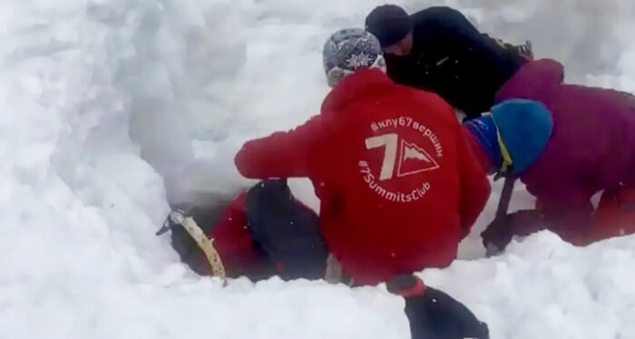 rescuers try to dig out an avalanche victim