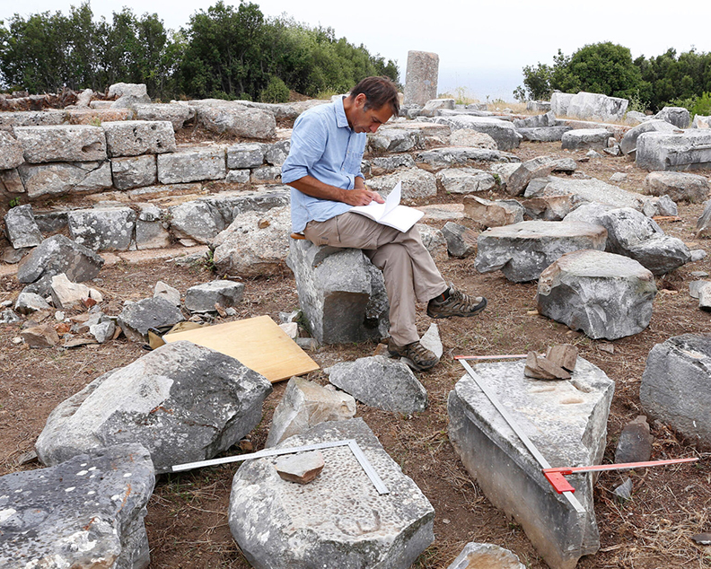 archaeologist taking notes amid ruins