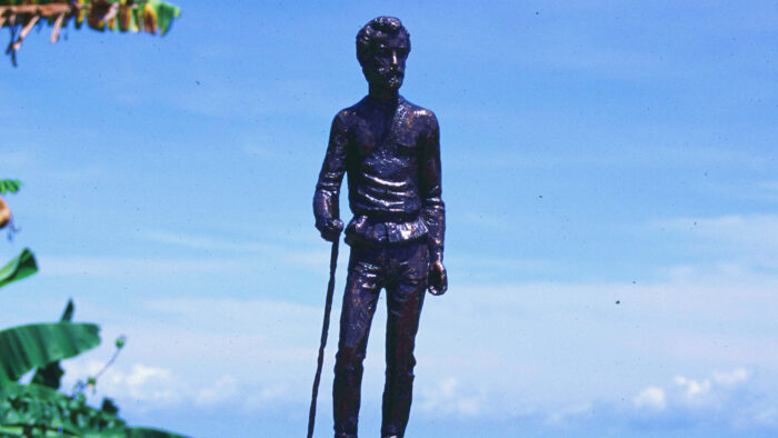 a small statue of a man holding a stick