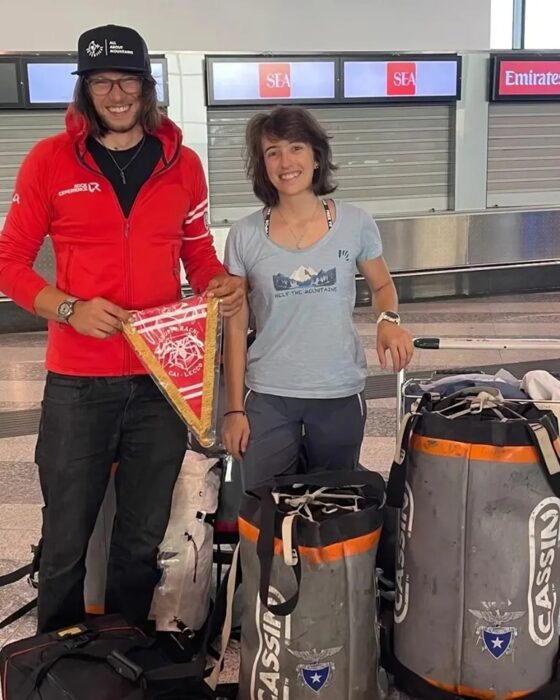 The climbers at an airport with they bags ready to be checked in. 