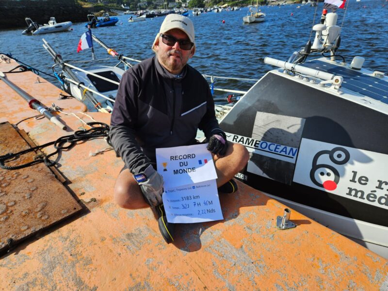 Patrick Favre with his boat and a sign showing his new record.