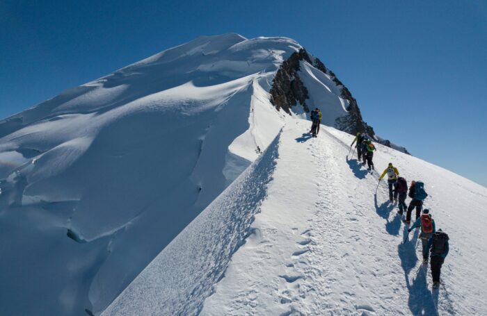 Climbers line up on a snowy ridge on Mont Blanc