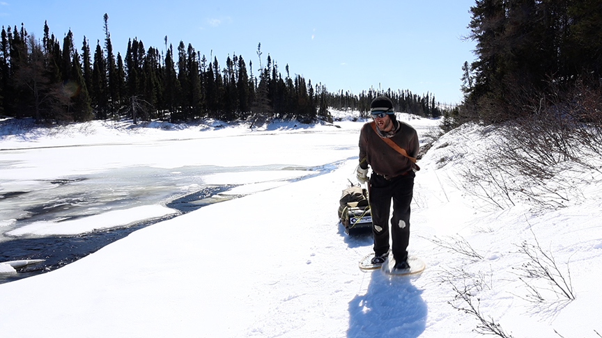 hauling a toboggan along a frozen river