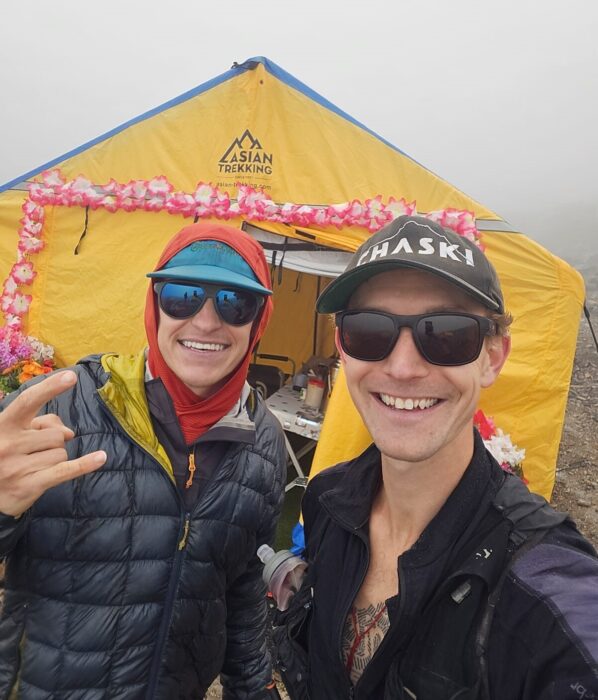 The climbers in front of a tent, with sunglasses in foggy weather