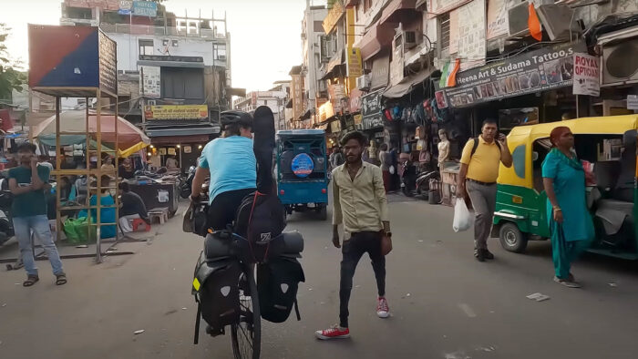 a cyclist rides through a busy Indian street