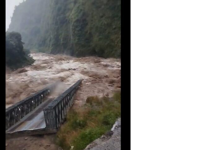 A bridge gets dragged by the flooded river. 