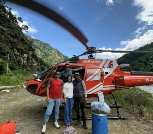 A group in front of a helicopter