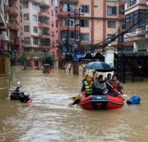 rescuers in a dingy boat sailing the flooded streets of Kathmandu, Nepal