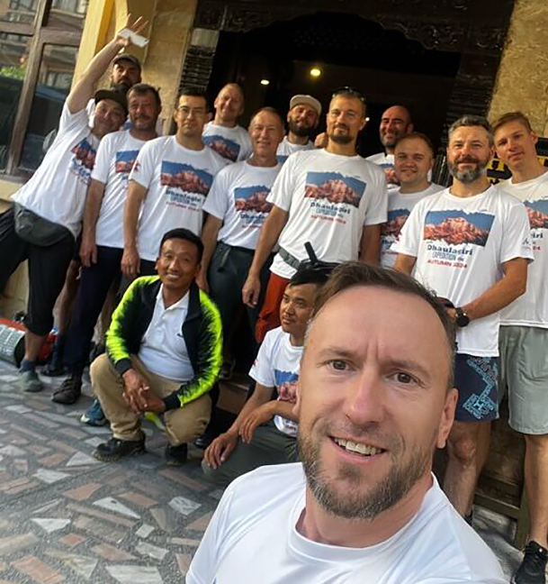 The team poses in front of a hotel