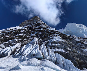 A rocky face with thin spots of ice as seen from below.