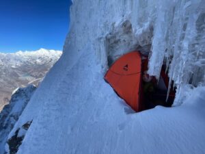 A tent in a snow niche on a very steep snow ramp on Ama Dablam