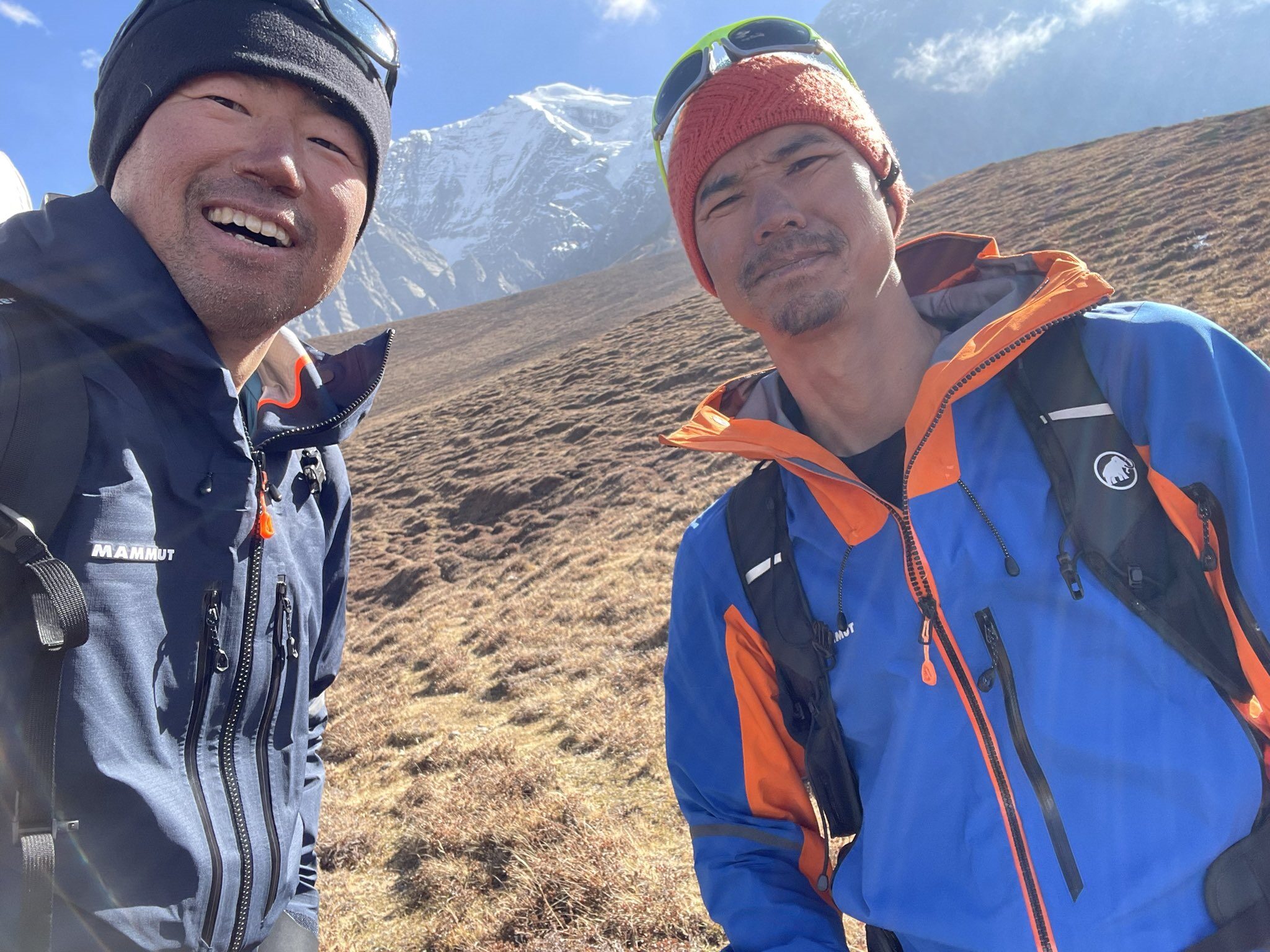 The climbers smile at a mountain spot