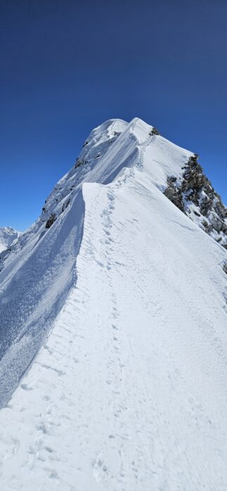 A snow ridge with a line of footprints near its edge