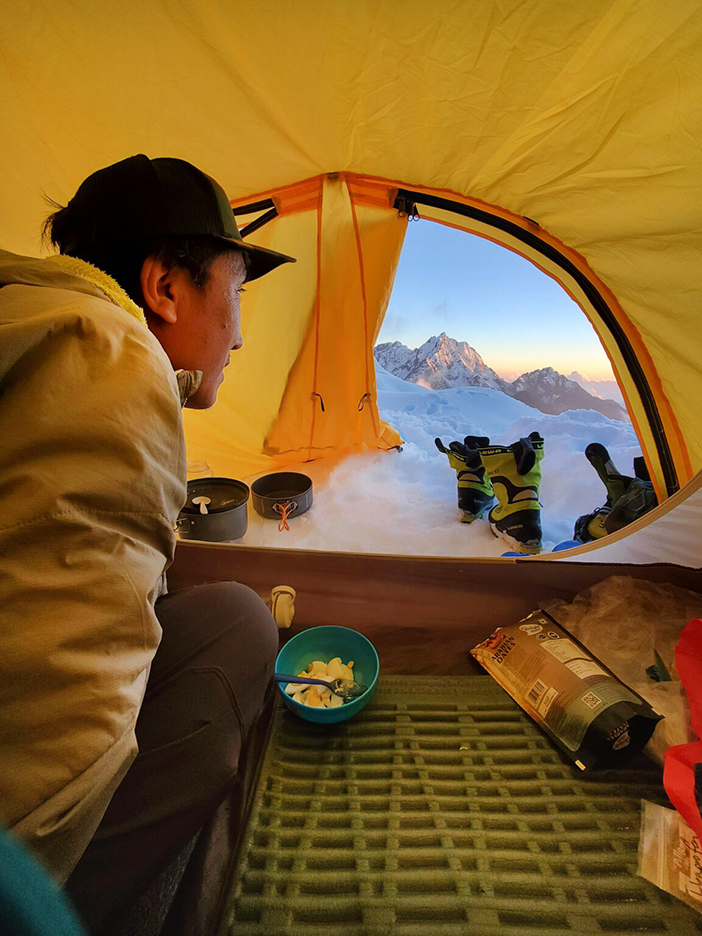 A Sherpa climber looking out from inside a tent